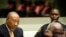 Former Liberian President Charles Taylor, left, waits for the start of his appeal judgement at the Special Court for Sierra Leone (SCSL) in Leidschendam, near The Hague, Netherlands, Sept. 26, 2013.