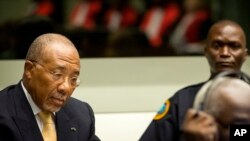Former Liberian President Charles Taylor, left, pictured at the Special Court for Sierra Leone near The Hague, Netherlands, Sept. 26, 2013.