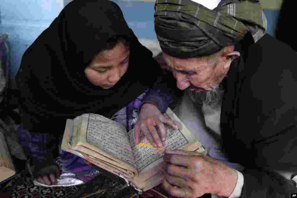 Seorang guru ngaji mengajar seorang anak perempuan Afghanistan membaca kitab suci al-Quran, di sebuah Madrasah di Kabul, Afghanistan.