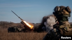 Ukrainian servicemen fire with a Bureviy multiple launch rocket system at a position in Donetsk region
