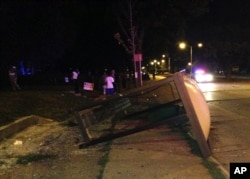 An overturned bus shelter lies on the ground after dozens of people protested following the fatal shooting of a man in Milwaukee, Saturday, Aug. 13, 2016.