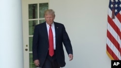 FILE - President Donald Trump walks out of the Oval Office into the Rose Garden of the White House in Washington, June 1, 2017. 