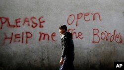 Un migrant passe devant des graffiti à Belgrade, Serbie, le 21 mars 2017.