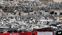 A worker sets banners at the port warehouses that were destroyed by Aug. 4 explosion that hit the seaport of Beirut, Lebanon, Aug. 19, 2020.