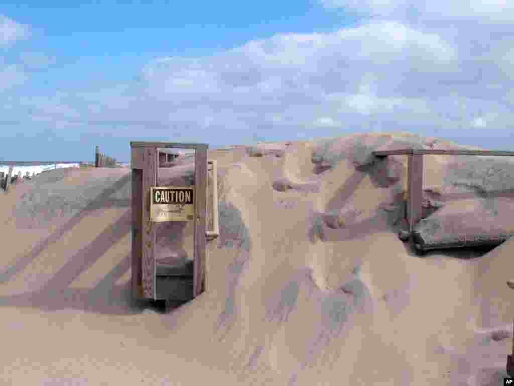 A beach entrance in Point Pleasant Beach, New Jersey, is buried under sand. Days of gusting wind and pounding surf have caused severe beach erosion in many spots along the New Jersey shore.