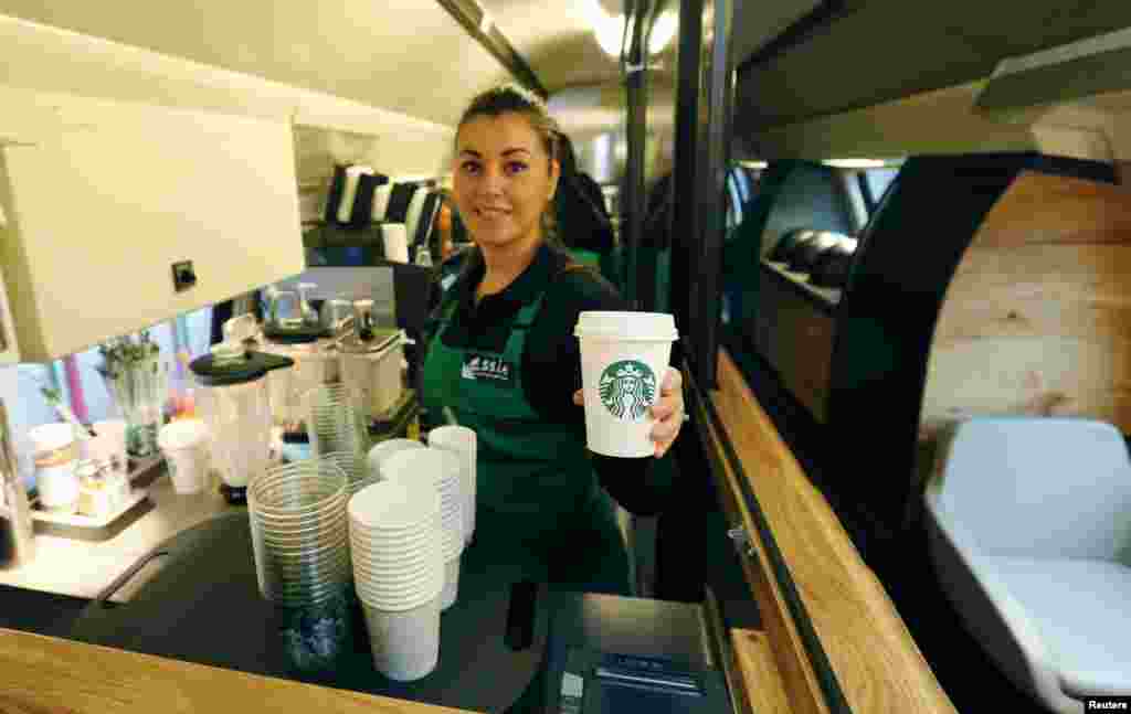 Seorang karyawati&nbsp; Starbucks memerlihatkan kopi Starbucks di kedai Starbucks yang baru di dalam kereta api Swiss SBB di Zurich. Starbucks, jaringan gerai kopi terbesar di dunia menghadirkan kedai bertingkat dua&nbsp; yang pertama di kereta api antarkota SBB dengan rute perjalanan antara kota Swiss St. Gallen dan Jenewa, 14 November 2013. 