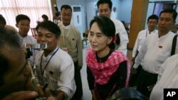 Aung San Suu Kyi (tengah) berbicara kepada media di Rangoon, Burma (27/5). 