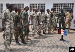 FILE - Soldiers accused of refusing to fight in the country's northeastern Islamic uprising appear before a court martial in Abuja, Nigeria, Oct. 2, 2014. The mass trial comes two weeks after 12 soldiers were sentenced to death by firing squad for mutiny and attempted murder of their commanding officer.