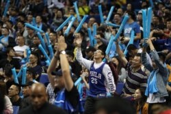 FILE - Fans cheer during the preseason NBA basketball game between the Philadelphia 76ers and the Dallas Mavericks in Shanghai, China, Oct. 5, 2018.