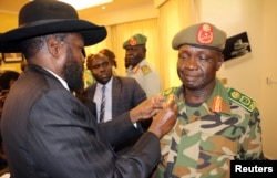 FILE - South Sudan's President Salva Kiir decorates newly appointed army chief General James Ajongo during his swearing-in ceremony at the Presidential Palace in Juba, South Sudan, May 10, 2017.