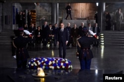 French President Francois Hollande (C) pays his respects after he placed a wreath at the Shoah memorial in Paris, Jan. 27, 2015.