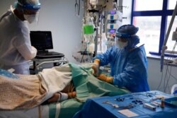 A doctor performs an ultrasound scan on a patient in a COVID-19 Intensive Care Unit at the Curry Cabral hospital in Lisbon, Portugal, Feb. 11, 2021.