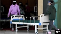 សមាជិកយោធាកម្ពុជារៀបចំគ្រែសម្រាប់អ្នកជំងឺកូវីដ១៩ នៅអគារក្នុងតំបន់កោះពេជ្រ រាជធានីភ្នំពេញ កាលពីថ្ងៃទី ១១ ខែមេសា ឆ្នាំ ២០២១។ 