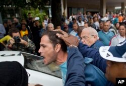 FILE - An opposition activist is detained by Cuban security officers ahead of a march marking International Human Rights Day in Havana, Cuba, Dec. 10, 2014.
