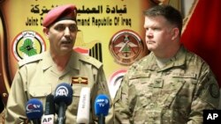 Gen. Yahya Rasool, left, an Iraqi military spokesman, speaks during a press conference with Col. John Dorrian, a U.S. spokesman for the coalition, in Baghdad, April 11, 2017.