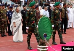 Bangladesh's Prime Minister Sheikh Hasina pays homage in front of the coffins of the victims who were killed in the attack on the Holey Artisan Bakery and the O'Kitchen Restaurant, during a memorial ceremony in Dhaka, July 4, 2016.