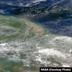 The Amazon River plume where it meets the Atlantic Ocean off Brazil's coast. River water is green. Credit NASA
