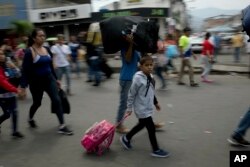 Venezuelans leave their country as they make their way to the Simon Bolivar international bridge in San Antonio del Tachira, Venezuela, on the border with Colombia, Feb. 21, 2019.