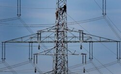 FILE - In this April 11, 2011 file photo, workers of the German energy company RWE prepare power supply on a high power pylon in Moers, Germany. The world's facing an energy crunch. (AP Photo)