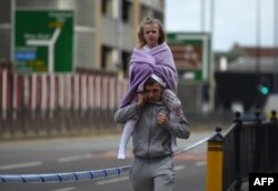 A man carries a young girl on his shoulders near Victoria station in Manchester, northwest England, May 23, 2017.