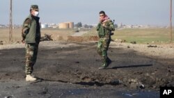 In this undated photo made available March 14, 2015, by the Kurdistan Region Security Council, Kurdish soldiers survey what Kurds now say was the site of a chemical-weapons attack between Mosul, Iraq, and the Syrian border in northern Iraq.