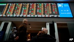 Two men talk underneath a display of Brazil's Bovespa index at Sao Paulo's Stock Exchange, Oct. 29, 2018.
