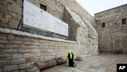 Seorang peziarah berdoa di luar Gereja Nativity di Betlehem, Tepi Barat, 5 Maret 2020. Pihak berwenang Palestina mengatakan gereja ini akan ditutup tanpa batas waktu untuk mengantisipasi merebaknya virus corona.