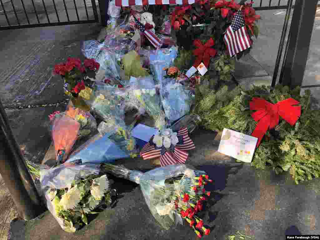Flowers, flags and a teddy bear are seen outside the gates of President George H.W. Bush's home in Houston, Texas, Dec. 5, 2018.