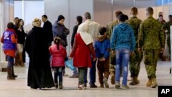 FILE - Syrian refugees wait at Marka Airport in Amman, Jordan, to complete their migration procedures to Canada, Dec. 8, 2015.