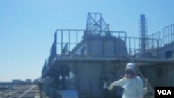 Seorang petugas di Jepang menunjukkan retakan yang ditemukan dekat reaktor No. 2 PLTN Fukushima, Minggu (3/4).