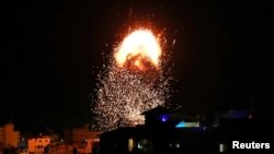 Asap dan kobaran api membubung di atas gedung saat serangan udara oleh Israel di tengah meningkatnya konflik bersenjata antara Israeli dan Palestinian di Kota Gaza, 17 Mei 2021. 