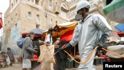 A health worker wearing a protective suit disinfects a market amid concerns of the spread of the coronavirus disease (COVID-19), in Sanaa, Yemen, April 28, 2020.
