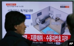 People watch a TV screen showing an image of solitary cell of Seoul Detention Center used by former South Korean President Park Geun-hye during a news program at the Seoul Railway Station in Seoul, South Korea, March 31, 2017.