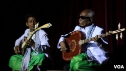 រូបឯកសារ៖ លោក​ម៉ើ មឿន អ្នក​​លេង​ចាប៉ី​​វ័យ​ក្មេង​ច្រៀង​ផ្ដោះផ្ដង​ជាមួយ​ព្រឹទ្ធាចារ្យ​ចាប៉ី​ជើង​ចាស់​គង់ ណៃ​ នៅ​ក្នុង​មហោស្រពចាប៉ី​លើក​ទីមួយ​នៅ​សាល​មហោស្រព​ចតុមុខនៃ​រាជធានី​ភ្នំពេញ​​កាលពី ថ្ងៃអាទិត្យ​ទី​០៣​មេសា​នេះ។ (​ឡេង ឡែន/VOA)