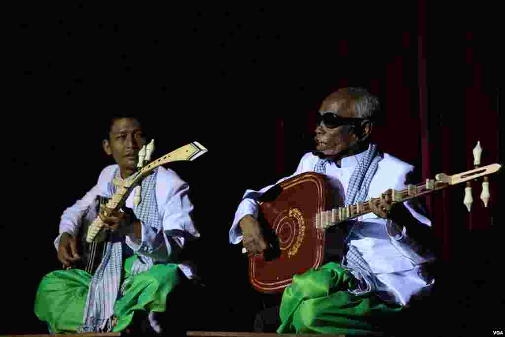 ម៉ើ មឿន អ្នក​​លេង​ចាប៉ី​​វ័យ​ក្មេង​ច្រៀង​ផ្ដោះផ្ដង​ជាមួយ​ព្រឹទ្ធាចារ្យ​ចាប៉ី​ជើង​ចាស់​គង់ ណៃ​ នៅ​ក្នុង​មហោស្រពចាប៉ី​លើក​ទីមួយ​នៅ​សាល​មហោស្រព​ចតុមុខនៃ​រាជធានី​ភ្នំពេញ​​កាលពី ថ្ងៃអាទិត្យ​ទី​០៣​មេសា​នេះ។ (​ឡេង ឡែន/VOA)