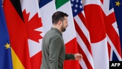 乌克兰总统泽连斯基在意大利普利亚地区出席G7峰会期间走过与会国旗帜。（2024年6月13日）