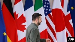 Perezida Volodymyr Zelensky wa Ukraine anyura imbere y'amabendera y'ibihugu bigize ihuriro rya G7 ribarizwamo ibihugu bikize kurusha ibindi ku Isi hari mu mujyi wa Savelletri mu Butaliyani taliki 13/6/ 2024.