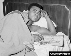 Muhammad Ali with a coloring book of military officers, time of soul searching for Ali who contemplating his response to a draft notice, 1967 (George Kalinsky)