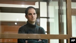 FILE - Reporter Wall Street Journal Evan Gershkovich berdiri di dalam sangkar kaca di ruang sidang Pengadilan Kota Moskow, di Moskow, Rusia, 14 Desember 2023.