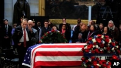 前参议员鲍勃·多尔从轮椅上站起来向老布什总统敬礼。(2018年12月4日)