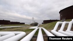 FILE PHOTO: Pipelines run to Enbridge Inc.'s crude oil storage tanks at their tank farm in Cushing
