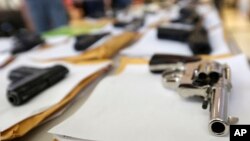 FILE - Chicago police display some of the thousands of illegal firearms they have confiscated in 2014 in their battle against gun violence in Chicago, July 7, 2014.
