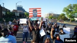A man holds a sign with a target as he joins other protesters during a protest against the death in Minneapolis police custody of African-American man George Floyd, in St Louis, Missouri, May 29, 2020. 