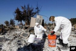 David Rust, left, and his wife Shelly search through the remains of their home destroyed by wildfires in Santa Rosa, California, Oct. 31, 2017.
