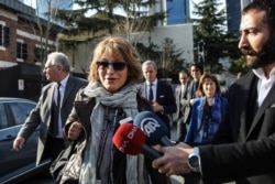 United Nations Special Rapporteur Agnes Callamard, surrounded by members of the media, walks around the Saudi Consulate, background, in Istanbul, Jan. 29, 2019. Callamard was investigating the death of Saudi journalist Jamal Khashoggi.