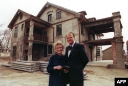 美国福音牧师葛培理和夫人钟路得在她在江苏省淮阴的出生地前留影。（1988年4月19日）