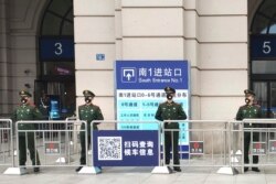 Paramilitary police stand guard at an entrance to the closed Hankou Railway Station in Wuhan in central China's Hubei Province, Jan. 23, 2020.