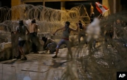 Lebanese anti-government protesters clash with riot police during a demonstration in Beirut, Aug. 29, 2015.