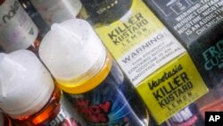 FILE - Flavored vaping solutions are shown at a vape and smoke shop, Sept. 16, 2019, in New York. New York and Canadian officials are weighing bans on certain e-cigarette flavors.
