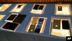 A collection of Apple iPhones and iPads fill a table during a news conference at New York City Police Headquarters, Feb. 18, 2016. Police and prosecutors in New York City said Thursday that the top-notch encryption technology on Apple mobile phones is no